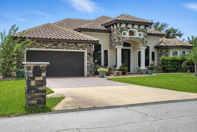 42 Felwood Ln, Palm Coast, FL 32137 - mediterranean / spanish-style home with stucco siding, an attached garage, driveway, a front yard, and stone siding