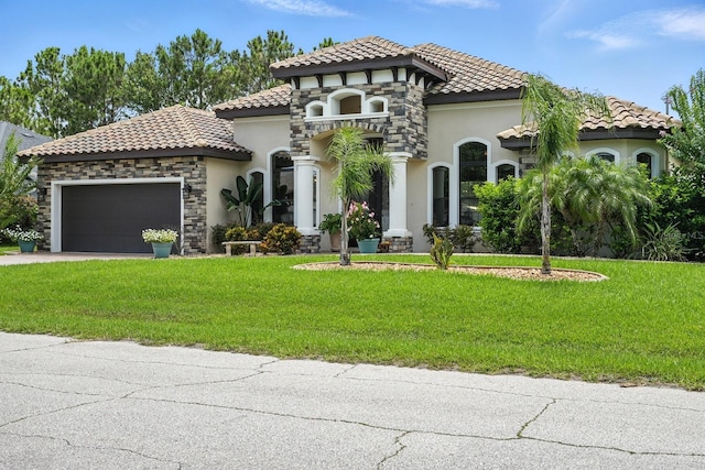 42 Felwood Ln, Palm Coast, FL 32137 - mediterranean / spanish-style home featuring stucco siding, an attached garage, a tile roof, and stone siding