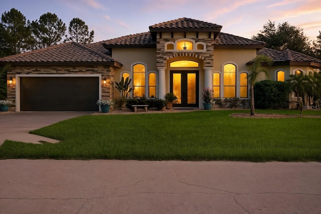 42 Felwood Ln, Palm Coast, FL 32137 - mediterranean / spanish-style house featuring stucco siding, concrete driveway, a yard, and a tile roof