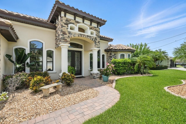 42 Felwood Ln, Palm Coast, FL 32137 - view of front facade featuring stucco siding, a tile roof, a front lawn, and french doors