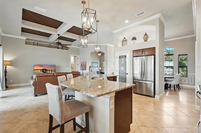 42 Felwood Ln, Palm Coast, FL 32137 - kitchen with freestanding refrigerator, a ceiling fan, a kitchen breakfast bar, light tile patterned floors, and a kitchen island with sink