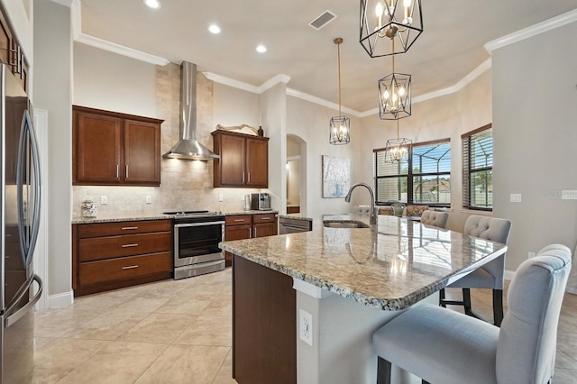 42 Felwood Ln, Palm Coast, FL 32137 - kitchen featuring stainless steel appliances, wall chimney exhaust hood, a chandelier, a breakfast bar, and arched walkways