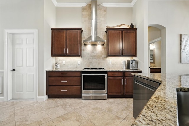 42 Felwood Ln, Palm Coast, FL 32137 - kitchen with appliances with stainless steel finishes, wall chimney exhaust hood, decorative backsplash, crown molding, and light stone countertops