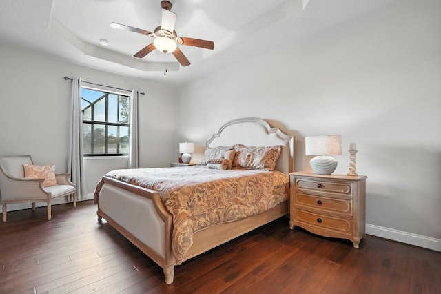 42 Felwood Ln, Palm Coast, FL 32137 - bedroom with a tray ceiling, dark wood-style flooring, and a ceiling fan