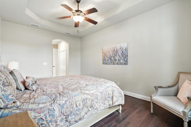 42 Felwood Ln, Palm Coast, FL 32137 - bedroom featuring arched walkways, a tray ceiling, dark wood finished floors, ceiling fan, and a closet