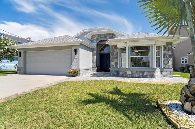 12 Comet Ct, Palm Coast, FL 32137 - ranch-style home with stone siding, an attached garage, a front lawn, and concrete driveway