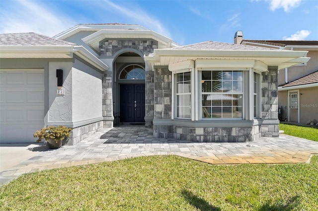 12 Comet Ct, Palm Coast, FL 32137 - property entrance with an attached garage, stone siding, and stucco siding