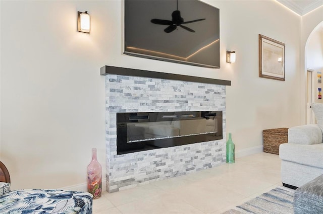 12 Comet Ct, Palm Coast, FL 32137 - living area with a stone fireplace, arched walkways, a ceiling fan, tile patterned flooring, and crown molding