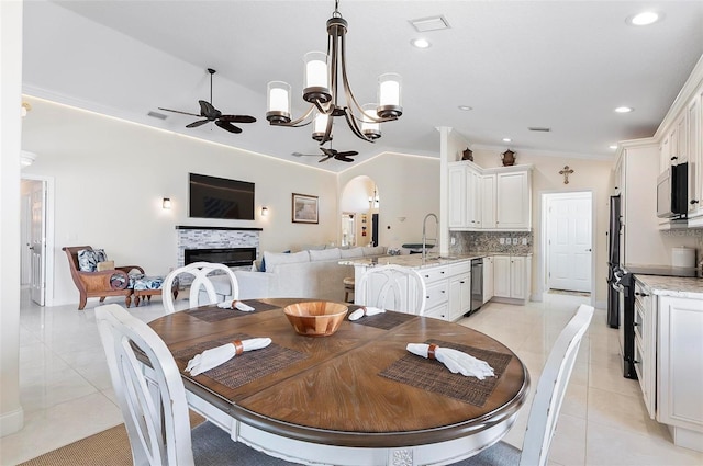 12 Comet Ct, Palm Coast, FL 32137 - dining area featuring light tile patterned floors, a ceiling fan, arched walkways, a glass covered fireplace, and a chandelier