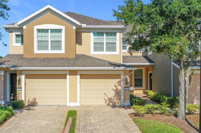 11781 Surfbird Cir Unit 6B, Jacksonville, FL 32256 - view of front of home featuring stucco siding, decorative driveway, an attached garage, and a shingled roof