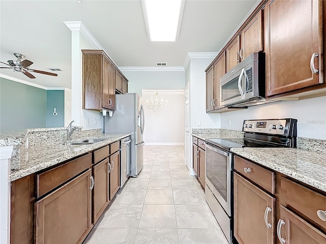 11781 Surfbird Cir Unit 6B, Jacksonville, FL 32256 - kitchen featuring stainless steel appliances, a ceiling fan, crown molding, light stone counters, and a chandelier