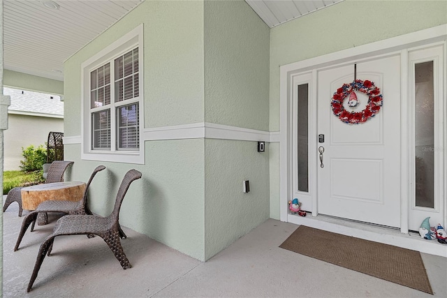 7 Pine Bush Ln, Palm Coast, FL 32164 - doorway to property featuring covered porch and stucco siding