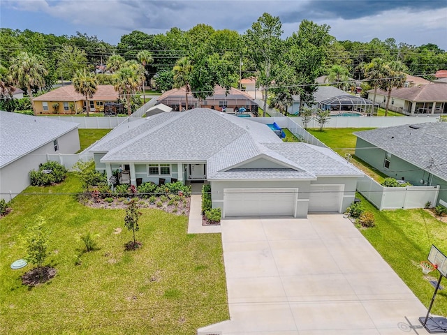 7 Pine Bush Ln, Palm Coast, FL 32164 - view of front of home featuring a garage, a fenced backyard, driveway, and roof with shingles