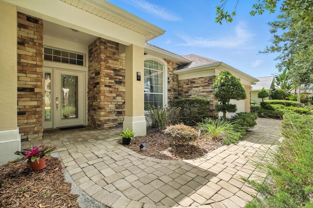 67 Lagare St, Palm Coast, FL 32137 - entrance to property with brick siding, roof with shingles, and stone siding