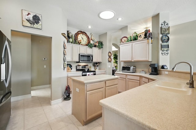 67 Lagare St, Palm Coast, FL 32137 - kitchen featuring appliances with stainless steel finishes, a kitchen island, light countertops, a textured ceiling, and light tile patterned floors