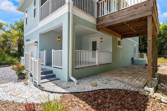 19 Bay Dr, Palm Coast, FL 32137 - view of side of home with stucco siding, an attached garage, and covered porch