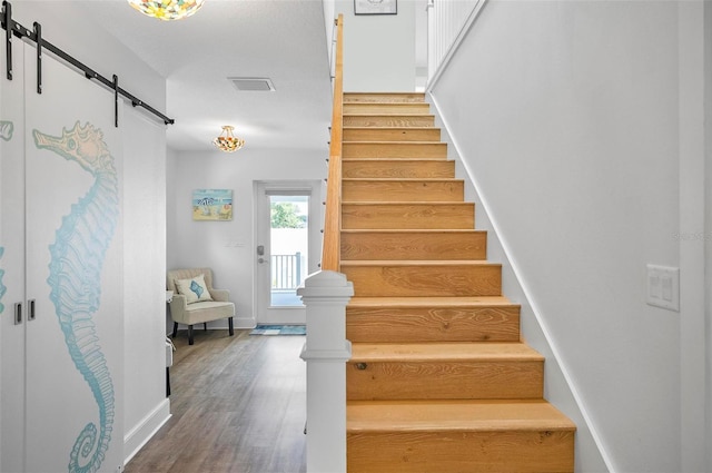 19 Bay Dr, Palm Coast, FL 32137 - staircase featuring a barn door and wood finished floors