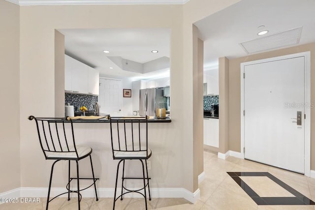 231 Riverside Dr Unit 103-1, Daytona Beach, FL 32117 - kitchen featuring freestanding refrigerator, a breakfast bar, white cabinetry, dark countertops, and recessed lighting