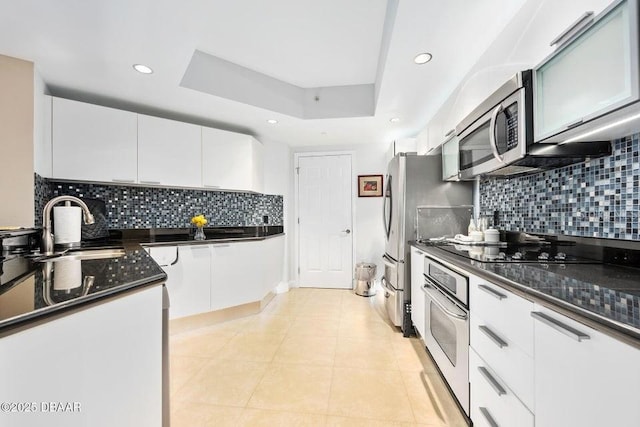 231 Riverside Dr Unit 103-1, Daytona Beach, FL 32117 - kitchen with appliances with stainless steel finishes, white cabinets, recessed lighting, a raised ceiling, and tasteful backsplash