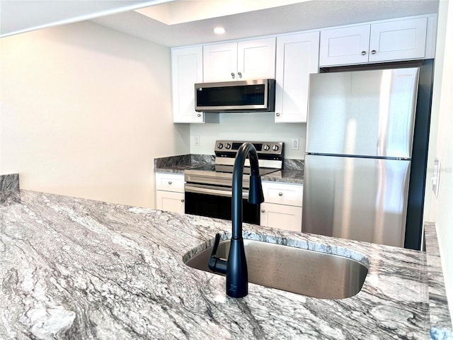 3628 S Central Ave Unit 5, Flagler Beach, FL 32136 - kitchen featuring stainless steel appliances, stone counters, and white cabinets