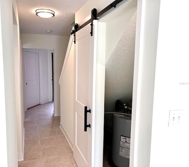 3628 S Central Ave Unit 5, Flagler Beach, FL 32136 - hall featuring water heater, a barn door, light tile patterned floors, and a textured ceiling