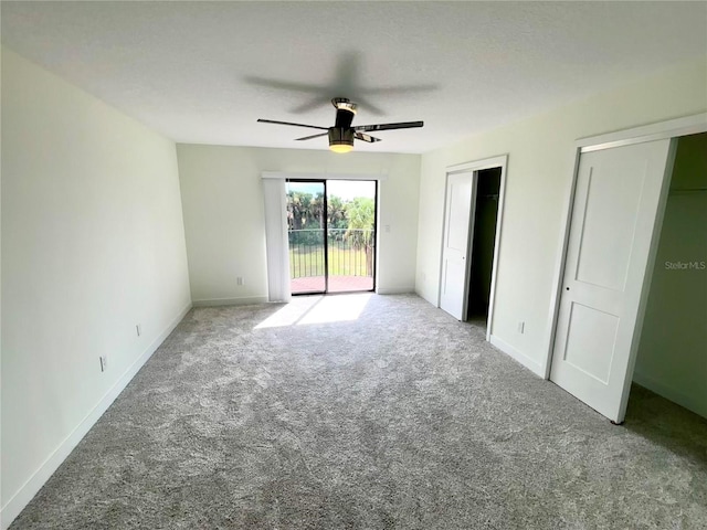 3628 S Central Ave Unit 5, Flagler Beach, FL 32136 - unfurnished bedroom featuring access to exterior, carpet flooring, a ceiling fan, and two closets