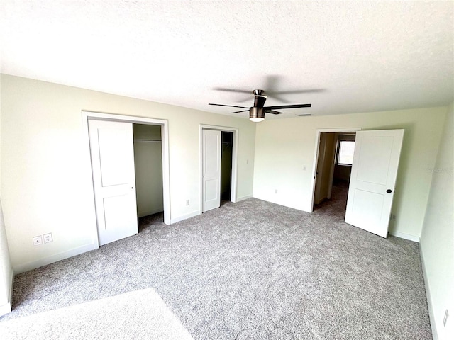 3628 S Central Ave Unit 5, Flagler Beach, FL 32136 - unfurnished bedroom with carpet flooring, two closets, a textured ceiling, and a ceiling fan