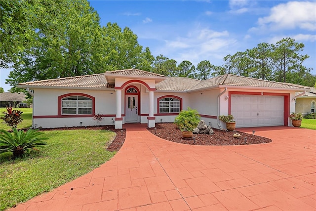 54 Pine Grove Dr, Palm Coast, FL 32164 - mediterranean / spanish-style home with a tile roof, a front lawn, a garage, stucco siding, and driveway