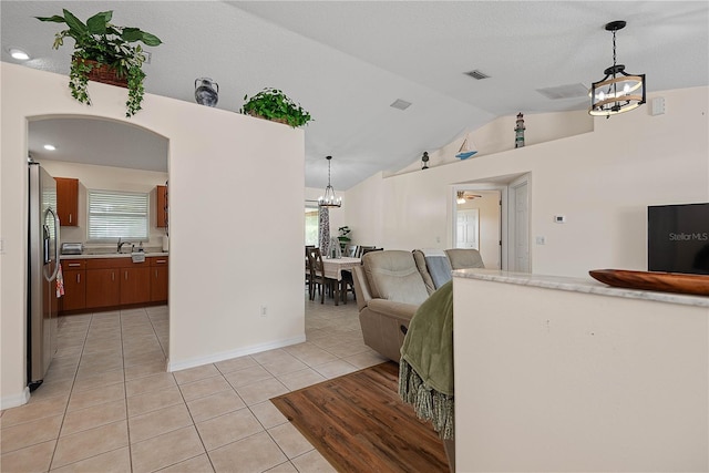 54 Pine Grove Dr, Palm Coast, FL 32164 - living area featuring a chandelier, vaulted ceiling, and light tile patterned flooring