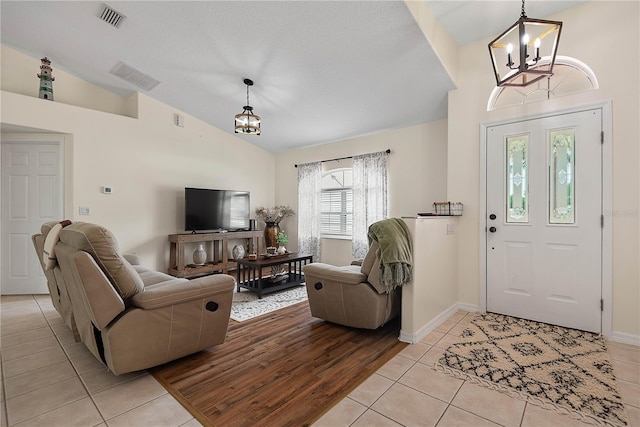 54 Pine Grove Dr, Palm Coast, FL 32164 - foyer with a chandelier, light tile patterned floors, and high vaulted ceiling
