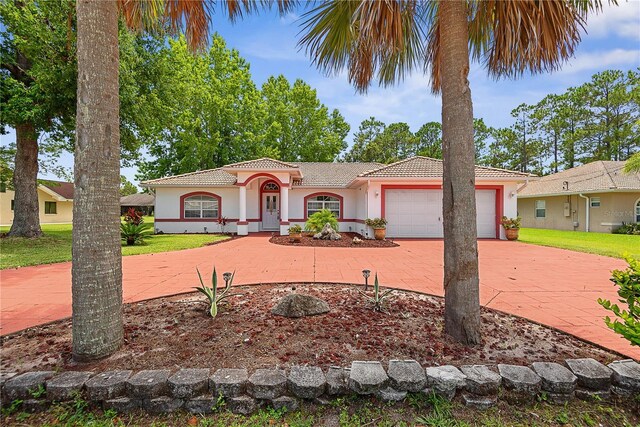 54 Pine Grove Dr, Palm Coast, FL 32164 - mediterranean / spanish home featuring stucco siding, a tiled roof, curved driveway, and an attached garage