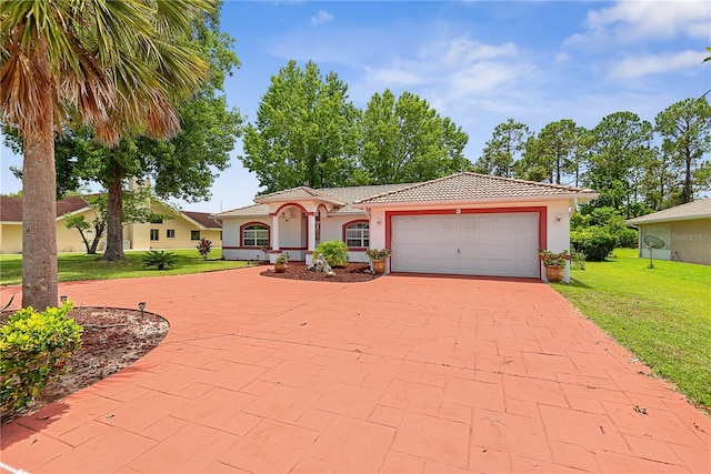 54 Pine Grove Dr, Palm Coast, FL 32164 - mediterranean / spanish-style house with a front lawn, a garage, stucco siding, driveway, and a tile roof