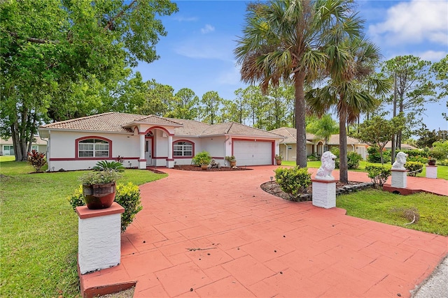 54 Pine Grove Dr, Palm Coast, FL 32164 - mediterranean / spanish home with a garage, stucco siding, a front lawn, and decorative driveway