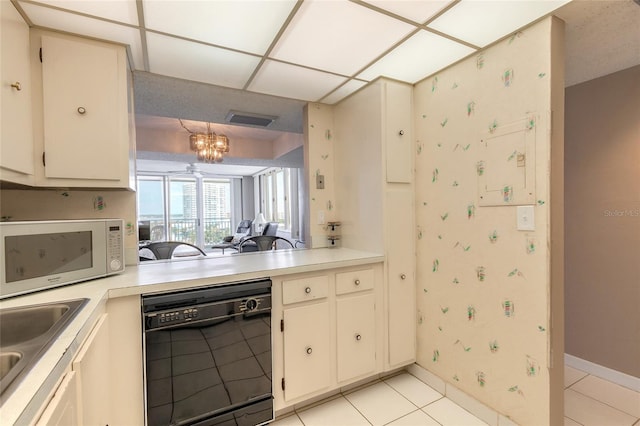 3047 S Atlantic Ave Unit 706, Daytona Beach, FL 32118 - kitchen featuring black dishwasher, white microwave, light countertops, light tile patterned floors, and wallpapered walls