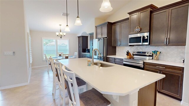 90 Randolph Dr, Palm Coast, FL 32164 - kitchen featuring stainless steel appliances, a kitchen island with sink, a chandelier, backsplash, and dark brown cabinets