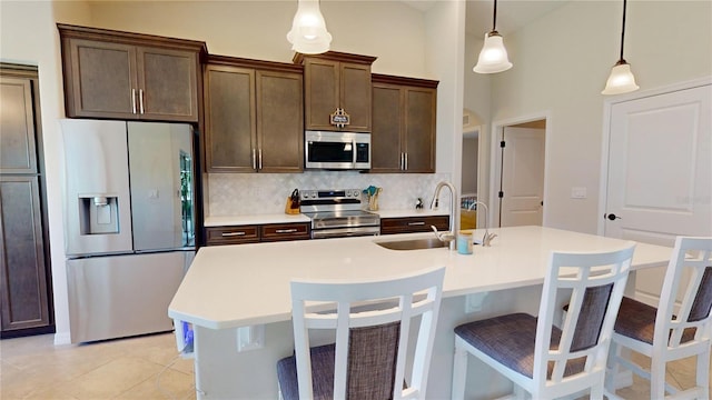 90 Randolph Dr, Palm Coast, FL 32164 - kitchen with stainless steel appliances, backsplash, light countertops, a breakfast bar area, and a center island with sink