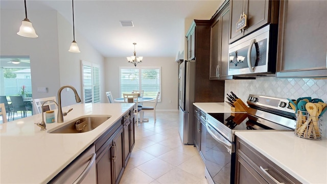 90 Randolph Dr, Palm Coast, FL 32164 - kitchen featuring appliances with stainless steel finishes, a chandelier, tasteful backsplash, light countertops, and hanging light fixtures