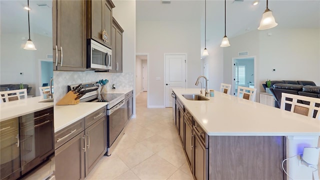 90 Randolph Dr, Palm Coast, FL 32164 - kitchen featuring stainless steel appliances, a towering ceiling, decorative backsplash, open floor plan, and light countertops