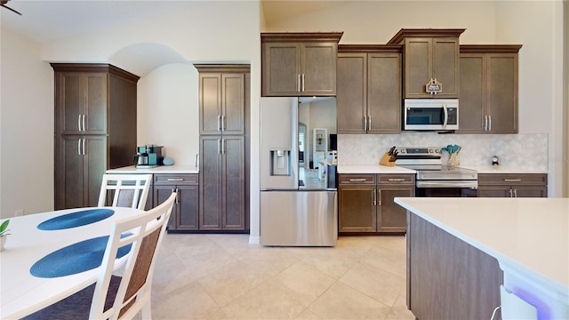 90 Randolph Dr, Palm Coast, FL 32164 - kitchen with stainless steel appliances, decorative backsplash, light countertops, dark brown cabinets, and light tile patterned floors