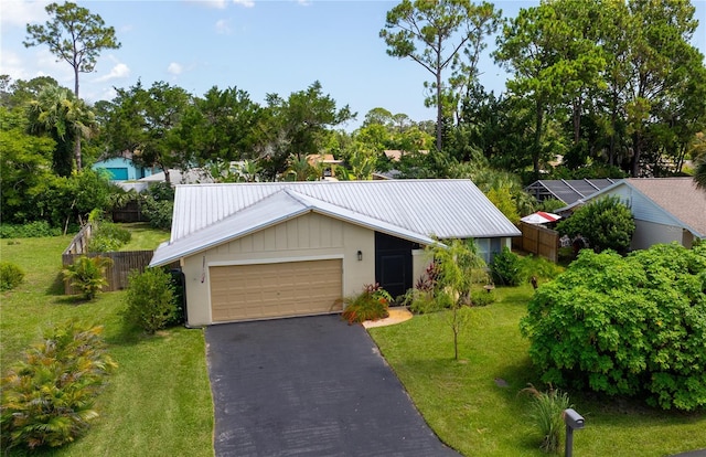 9 Collins Ln, Palm Coast, FL 32137 - view of front of house with a metal roof, driveway, and an attached garage