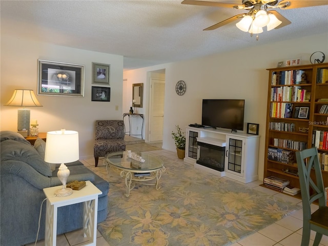 9 Collins Ln, Palm Coast, FL 32137 - tiled living area with a ceiling fan, a glass covered fireplace, and a textured ceiling