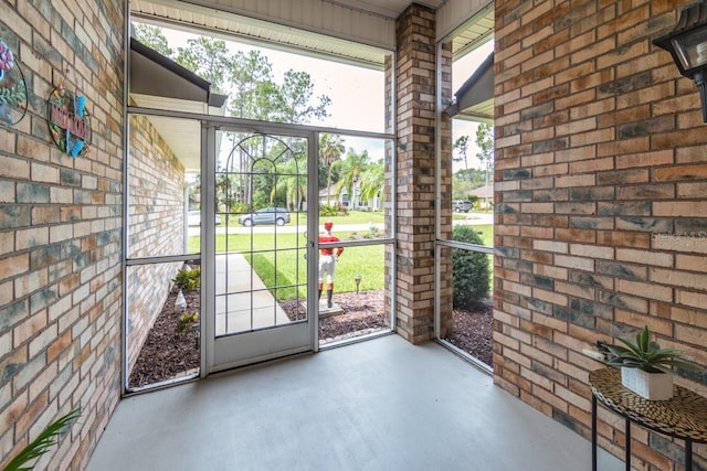 4 Essington Ln, Palm Coast, FL 32164 - doorway to outside featuring finished concrete flooring and brick wall