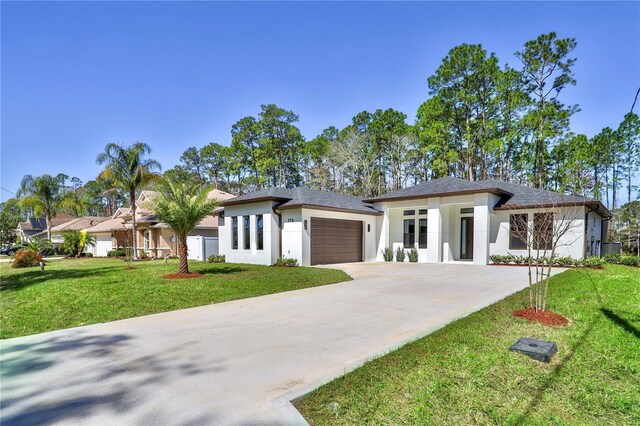 179 Eric Dr, Palm Coast, FL 32164 - prairie-style home featuring stucco siding, an attached garage, concrete driveway, and a front lawn