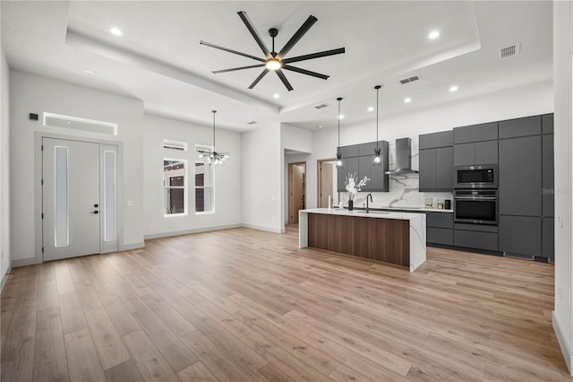 179 Eric Dr, Palm Coast, FL 32164 - kitchen with stainless steel appliances, wall chimney range hood, a raised ceiling, modern cabinets, and recessed lighting