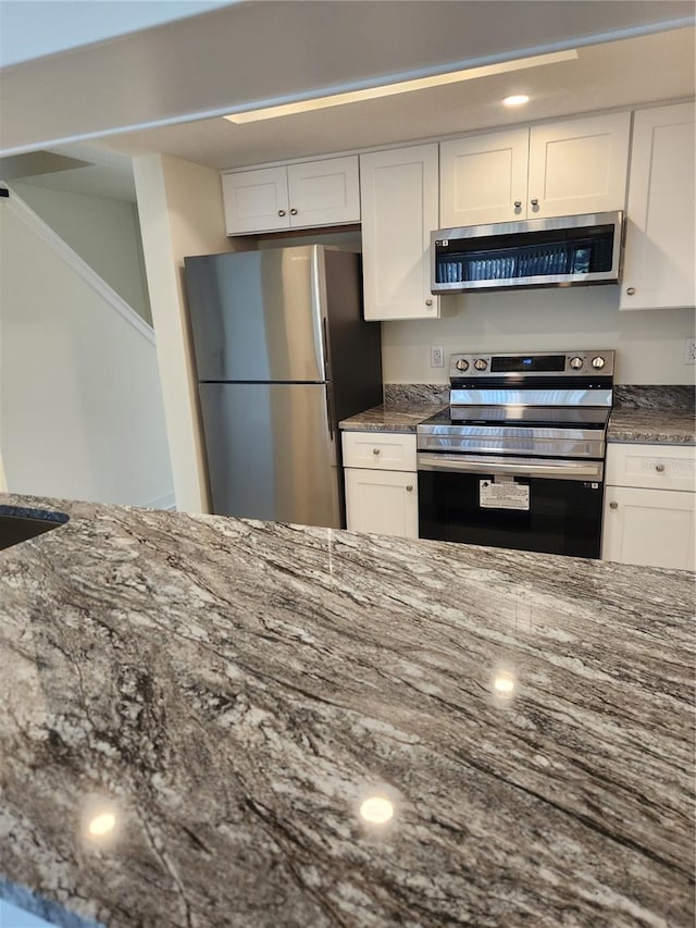 3630 S Central Ave, Flagler Beach, FL 32136 - kitchen featuring stainless steel appliances, range hood, dark stone countertops, white cabinets, and recessed lighting