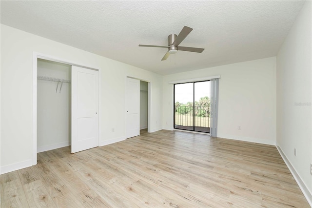 3630 S Central Ave, Flagler Beach, FL 32136 - unfurnished bedroom with multiple closets, access to outside, light wood finished floors, a ceiling fan, and a textured ceiling