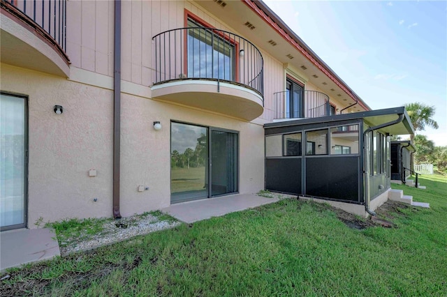 3630 S Central Ave, Flagler Beach, FL 32136 - rear view of house featuring a sunroom, a balcony, stucco siding, and a lawn