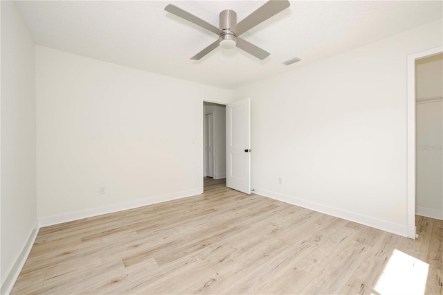 3630 S Central Ave, Flagler Beach, FL 32136 - unfurnished bedroom featuring a walk in closet, wood finished floors, a closet, and a ceiling fan