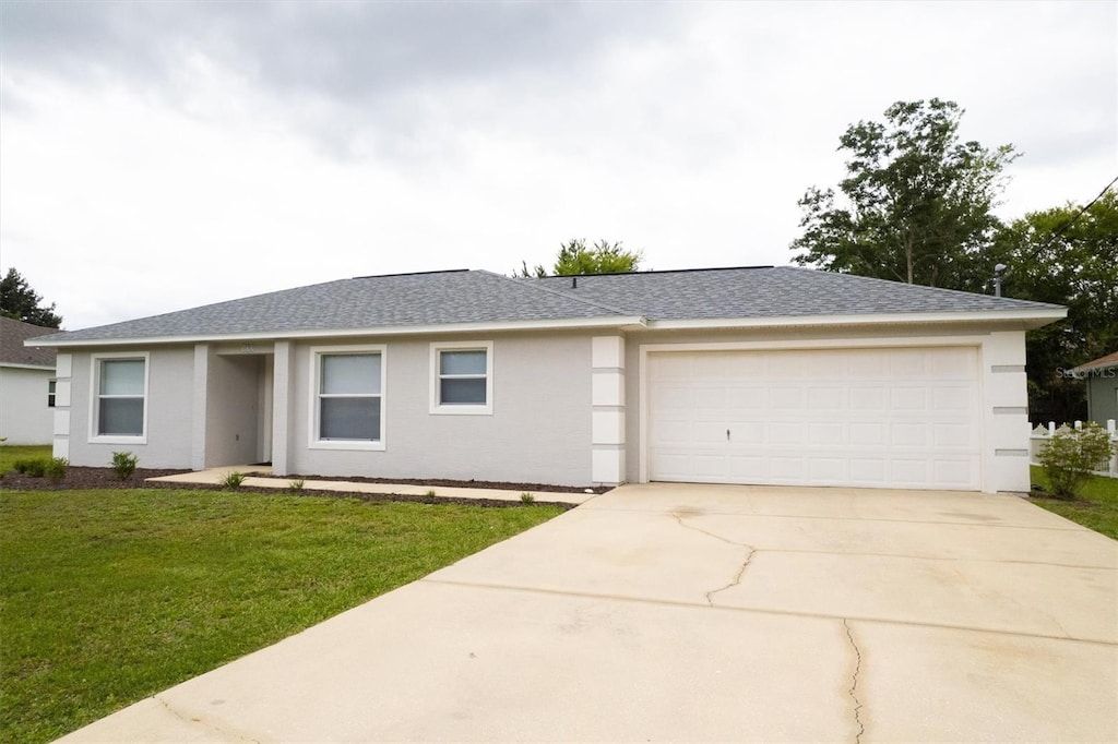 173 Bird Of Paradise Dr, Palm Coast, FL 32137 - ranch-style house with concrete driveway, a shingled roof, a front lawn, an attached garage, and stucco siding