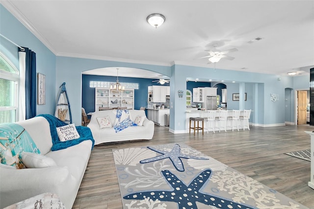 101 N 22nd St, Flagler Beach, FL 32136 - living area featuring arched walkways, ceiling fan, ornamental molding, a chandelier, and wood finished floors